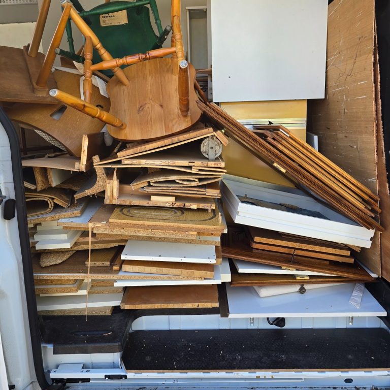 Ein überladener Transporter mit gestapeltem Holz und Möbelteilen.